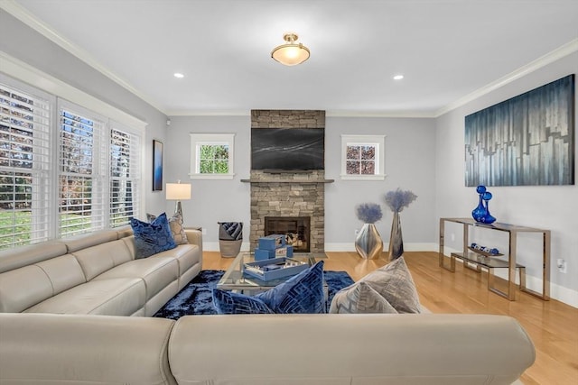 living room with crown molding, a stone fireplace, wood finished floors, and baseboards