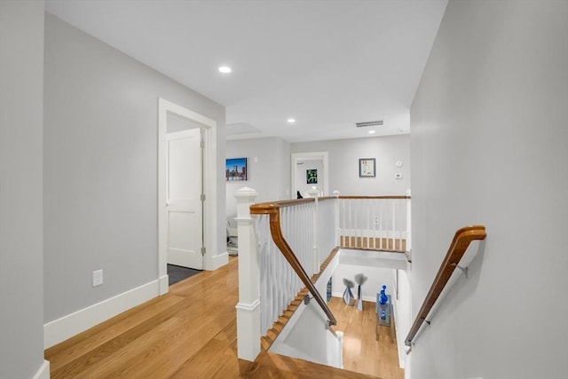 stairs with wood finished floors, visible vents, recessed lighting, and baseboards