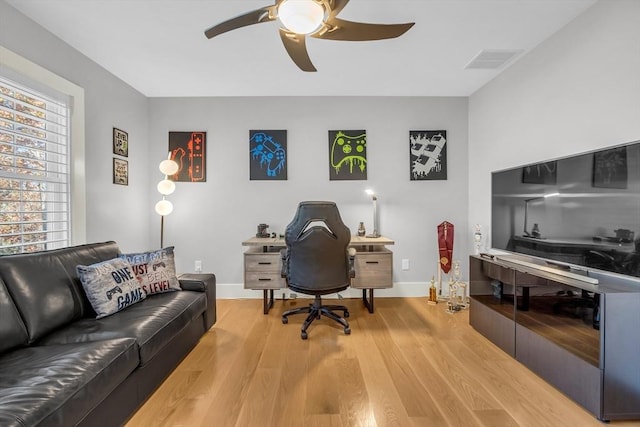 office area featuring a ceiling fan, visible vents, baseboards, and light wood-style floors