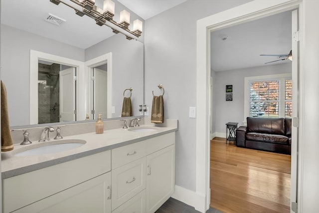 bathroom featuring visible vents, baseboards, a stall shower, and a sink
