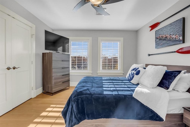 bedroom featuring baseboards, wood finished floors, and ceiling fan