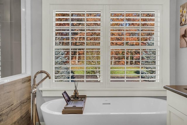 full bath with a soaking tub and vanity