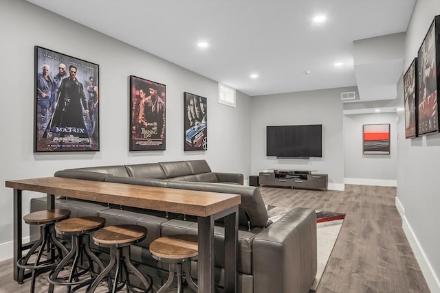 living area with baseboards, visible vents, and wood finished floors
