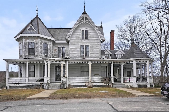 victorian house with a porch and a chimney