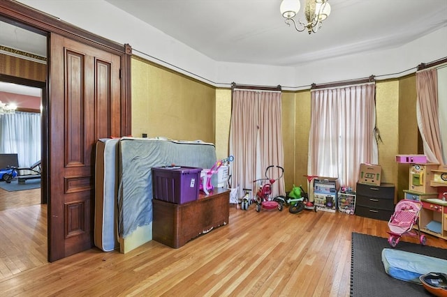 playroom featuring a chandelier and hardwood / wood-style flooring