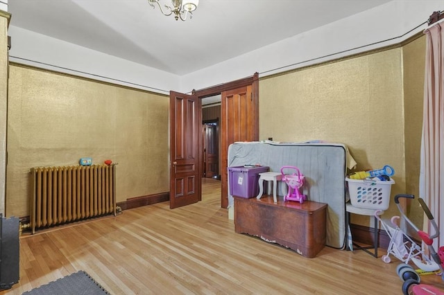 interior space with baseboards, wood finished floors, and radiator heating unit