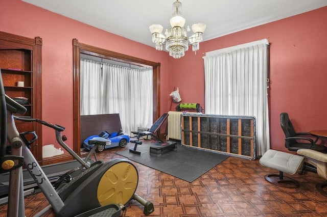 exercise area featuring an inviting chandelier