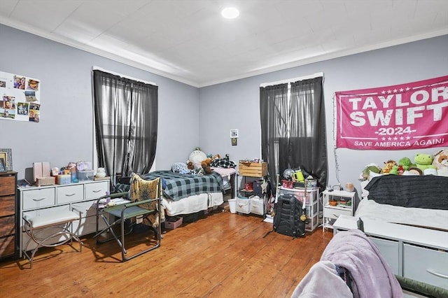 bedroom featuring hardwood / wood-style flooring and crown molding