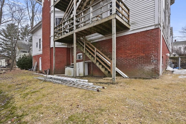 rear view of property with stairs and brick siding