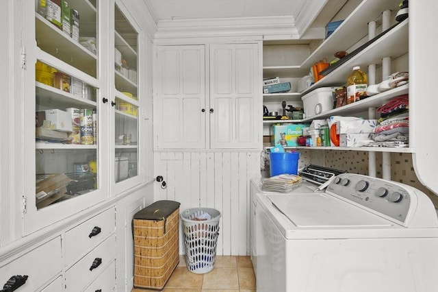 clothes washing area with light tile patterned floors, cabinet space, independent washer and dryer, and crown molding