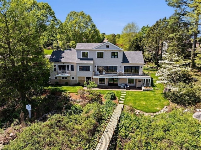 38 Old Shipyard Ln, Hanover, MA 02339 - back of house with a yard, roof with shingles, a balcony, view of scattered trees, and a chimney
