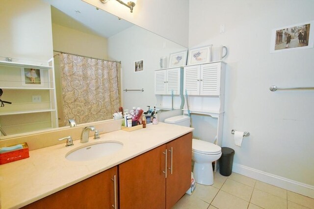 35 Commonwealth Ave Unit 404, Newton, MA 02467 - bathroom featuring tile patterned floors, toilet, baseboards, and vanity