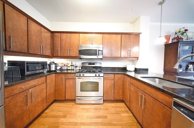 35 Commonwealth Ave Unit 404, Newton, MA 02467 - kitchen featuring appliances with stainless steel finishes, a sink, light wood finished floors, and dark stone counters