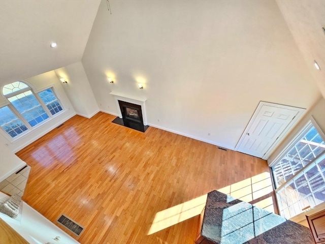 living room with wood-type flooring and a towering ceiling