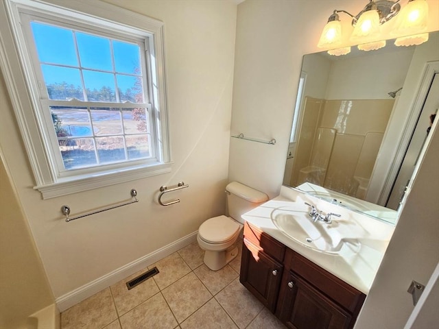 bathroom featuring tile patterned flooring, vanity, toilet, and walk in shower