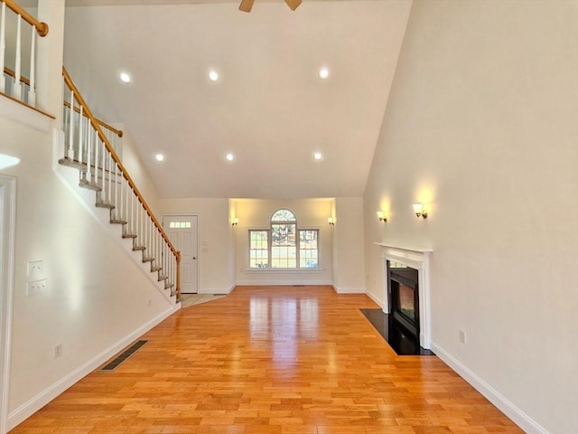 unfurnished living room featuring light hardwood / wood-style floors and high vaulted ceiling