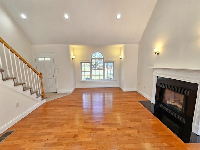 unfurnished living room featuring light hardwood / wood-style floors and lofted ceiling