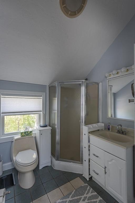 17 Woodcliff Rd, Quincy, MA 02169 - full bathroom with lofted ceiling, a shower stall, vanity, tile patterned flooring, and toilet