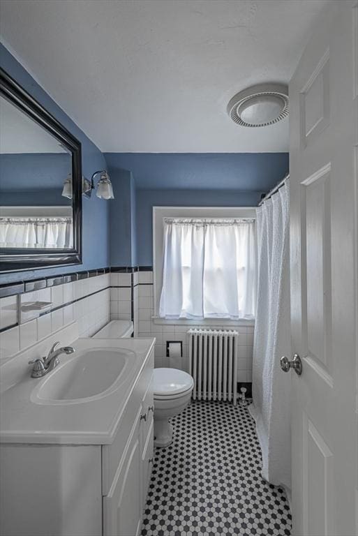 17 Woodcliff Rd, Quincy, MA 02169 - bathroom with radiator, plenty of natural light, toilet, vanity, and tile walls