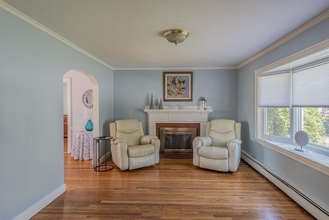 17 Woodcliff Rd, Quincy, MA 02169 - living area featuring baseboard heating, arched walkways, crown molding, wood finished floors, and a brick fireplace