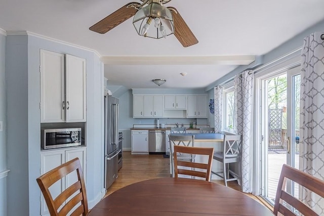 17 Woodcliff Rd, Quincy, MA 02169 - kitchen featuring stainless steel appliances, ceiling fan, white cabinetry, wood finished floors, and crown molding