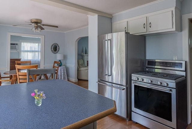 17 Woodcliff Rd, Quincy, MA 02169 - kitchen featuring stainless steel appliances, arched walkways, ornamental molding, a ceiling fan, and white cabinets