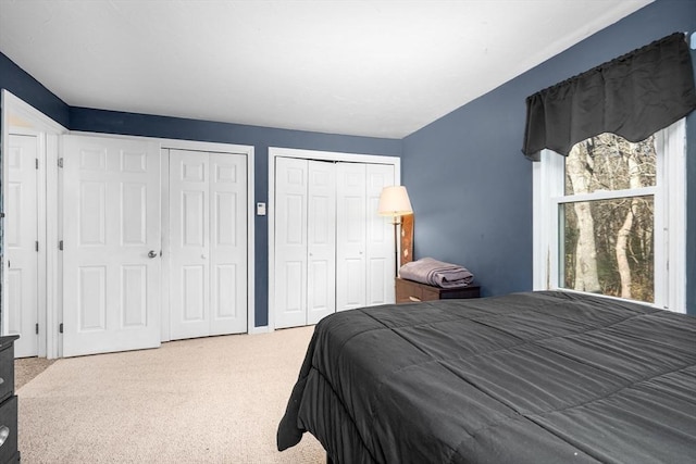 bedroom with carpet floors and two closets