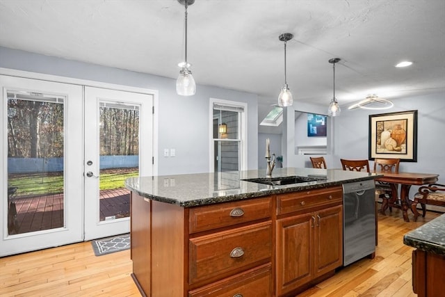 kitchen with french doors, dishwashing machine, a kitchen island with sink, pendant lighting, and dark stone countertops