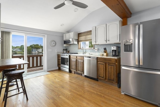 121 Lynnfield St, Lynn, MA 01904 - kitchen with stainless steel appliances, lofted ceiling, a ceiling fan, decorative backsplash, and light wood-type flooring