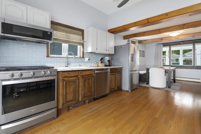 121 Lynnfield St, Lynn, MA 01904 - kitchen featuring stainless steel appliances, white cabinets, light countertops, light wood-style floors, and beamed ceiling