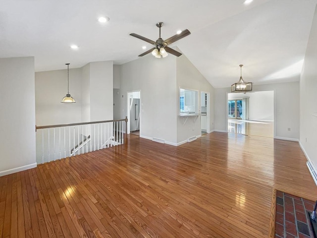 empty room featuring high vaulted ceiling, a ceiling fan, baseboards, and hardwood / wood-style floors