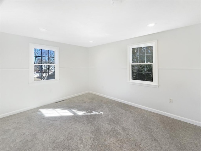 carpeted empty room with recessed lighting, visible vents, and baseboards