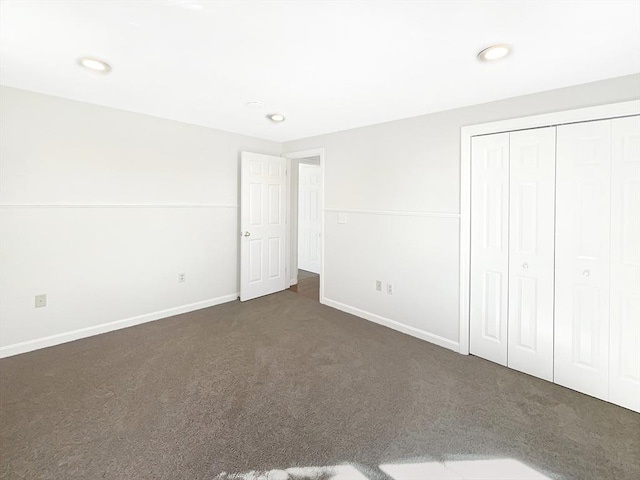 unfurnished bedroom with recessed lighting, carpet flooring, baseboards, and a closet