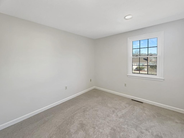 unfurnished room with carpet, baseboards, and visible vents