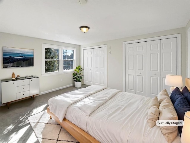 bedroom featuring baseboards, multiple closets, and carpet floors