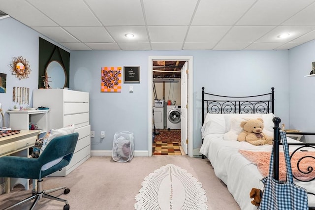 bedroom with a spacious closet, a drop ceiling, light carpet, and washing machine and dryer