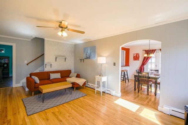 living area with hardwood / wood-style floors, a baseboard radiator, arched walkways, ceiling fan, and baseboard heating