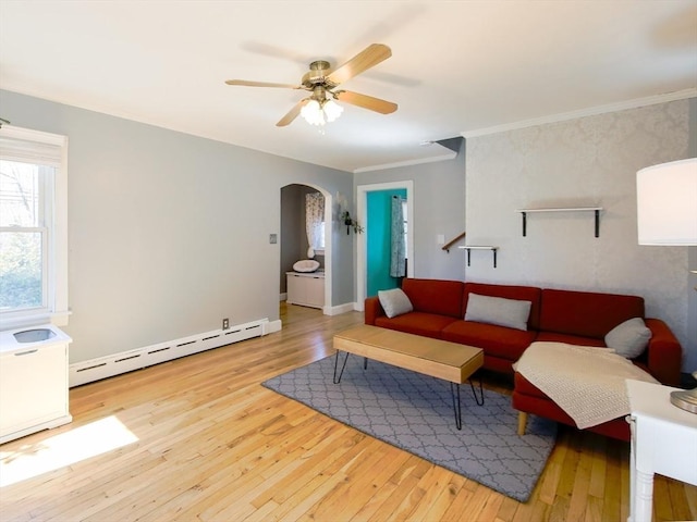 living area featuring ornamental molding, a ceiling fan, hardwood / wood-style flooring, arched walkways, and a baseboard radiator