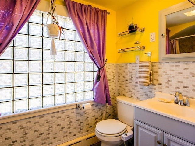 full bath with toilet, tile walls, plenty of natural light, and vanity