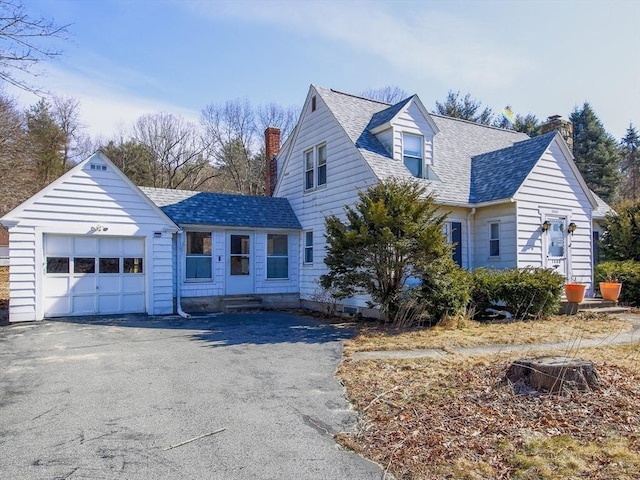 view of front of property with aphalt driveway, an attached garage, a chimney, and roof with shingles