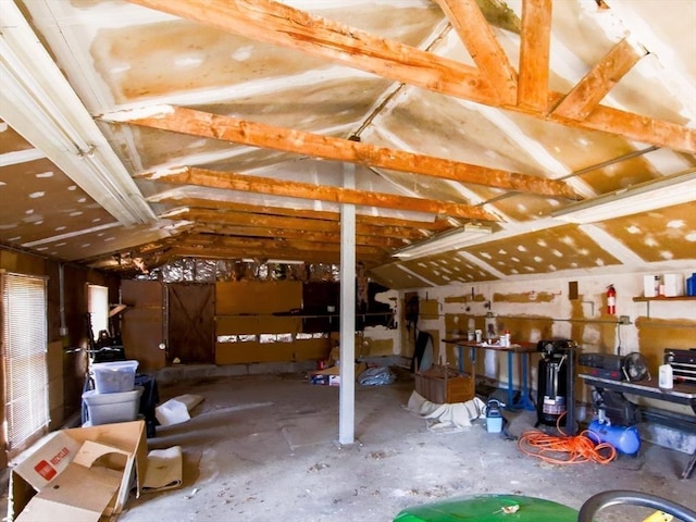 misc room with a garage and lofted ceiling