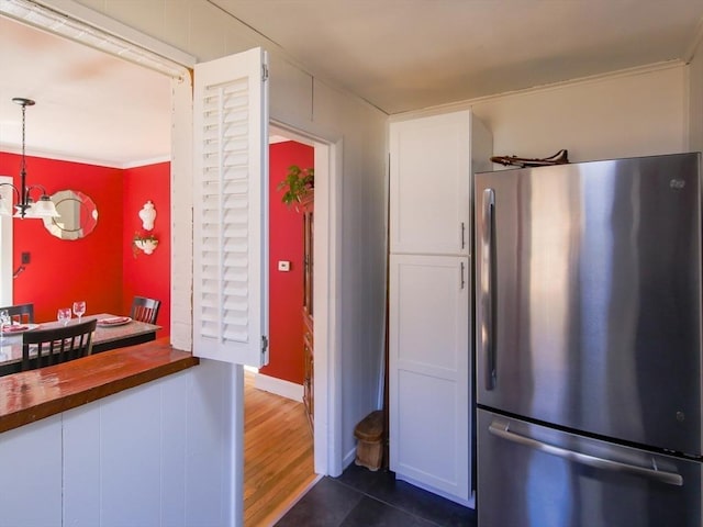 kitchen featuring dark wood-type flooring, a chandelier, freestanding refrigerator, white cabinets, and wood counters