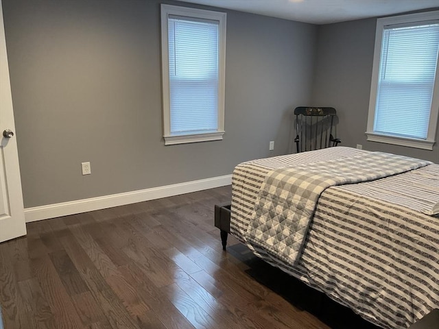 bedroom with baseboards and dark wood-type flooring