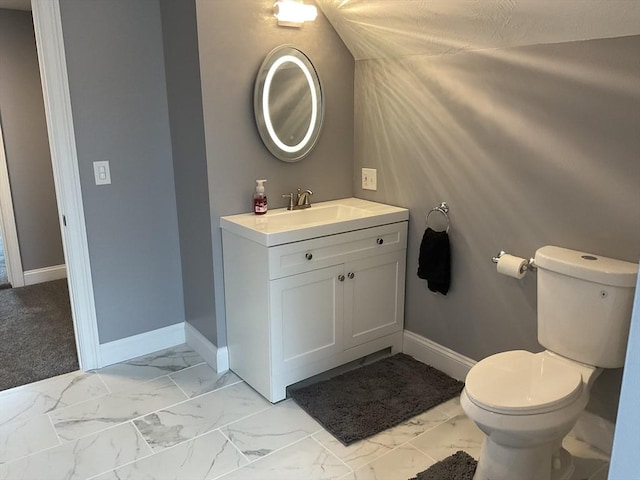 bathroom featuring marble finish floor, toilet, vanity, and baseboards