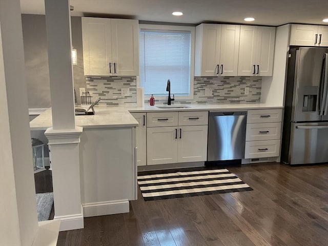 kitchen featuring a sink, light countertops, stainless steel appliances, white cabinetry, and dark wood-style flooring