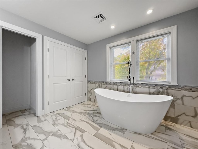 851 Forest St, North Andover, MA 01845 - full bath with tile walls, a freestanding tub, recessed lighting, wainscoting, and marble look tiles