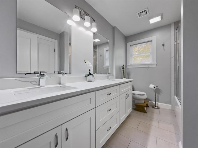 851 Forest St, North Andover, MA 01845 - full bathroom featuring toilet, double vanity, tile patterned flooring, and baseboards