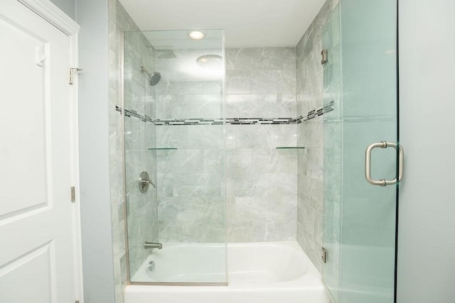 bathroom featuring bath / shower combo with glass door