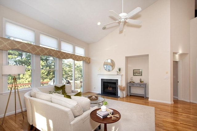 living room featuring light hardwood / wood-style floors, high vaulted ceiling, and plenty of natural light