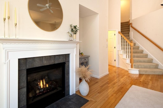 living room with hardwood / wood-style flooring, ceiling fan, and a fireplace